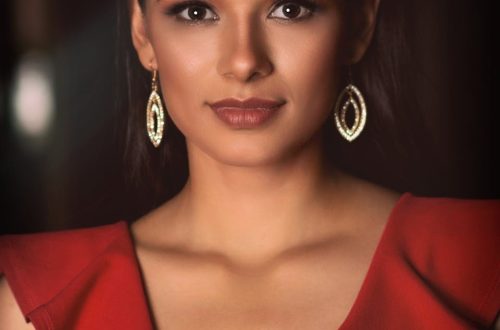 Stunning portrait of a woman in a red dress and elegant earrings, exuding confidence.