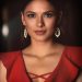 Stunning portrait of a woman in a red dress and elegant earrings, exuding confidence.