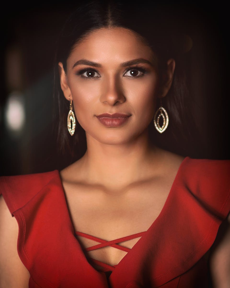 Stunning portrait of a woman in a red dress and elegant earrings, exuding confidence.